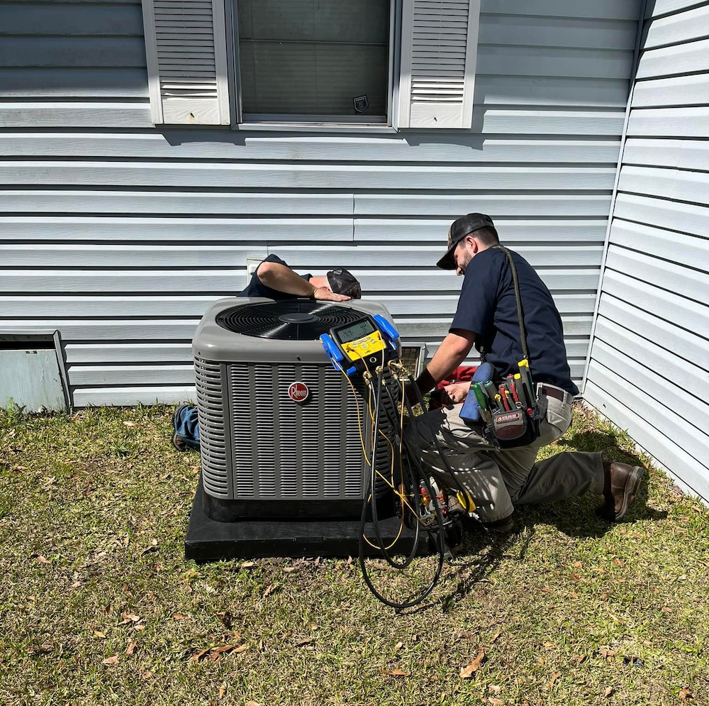 Two men repairing an AC unit.